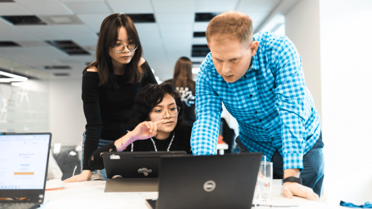 Trójka młodych osób pracujących nad swoim rozwiązaniem. Okładka dla filmu eventowego z hackathonu dla branży nieruchomości zrealizowany dla agencji Challenge Rocket
